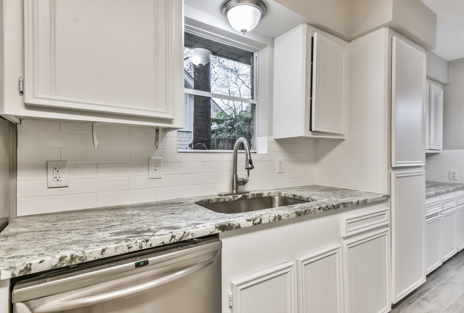 9718 John Bank Drive Spring, TX 77379 - Photo 14 of 39 a kitchen with granite countertop cabinets stainless steel appliances and a window