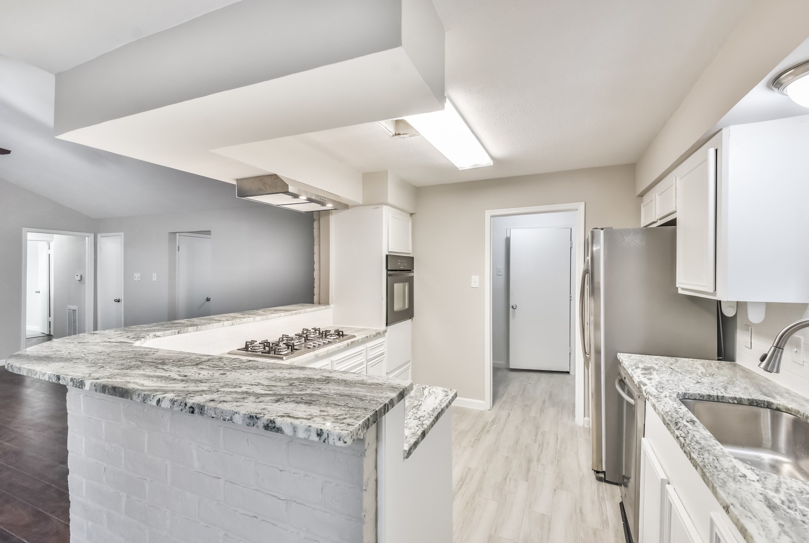 9718 John Bank Drive Spring, TX 77379 - Photo 16 of 39 a kitchen with granite countertop sink and refrigerator