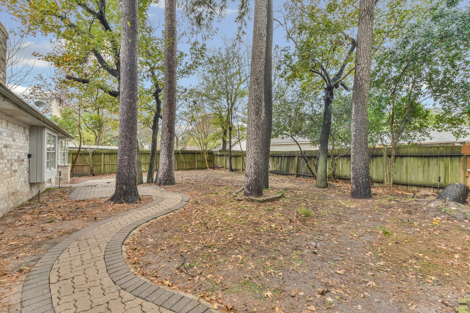 9718 John Bank Drive Spring, TX 77379 - Photo 37 of 39 a backyard of a house with large trees and wooden fence