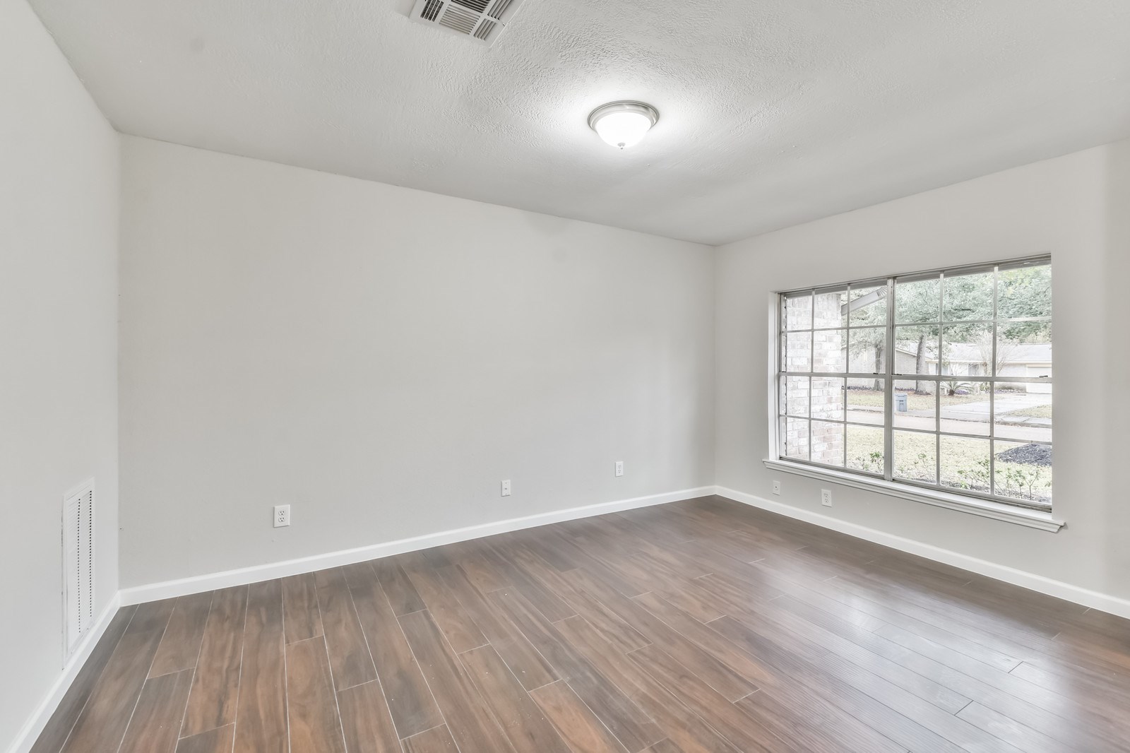 9718 John Bank Drive Spring, TX 77379 - Photo 7 of 39 an empty room with wooden floor and windows