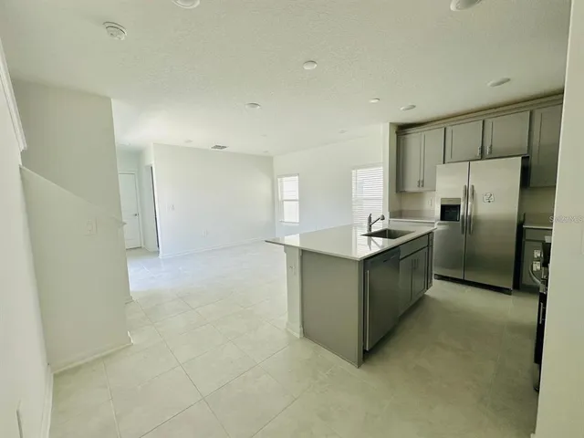 a view of kitchen with refrigerator cabinets and wooden floor