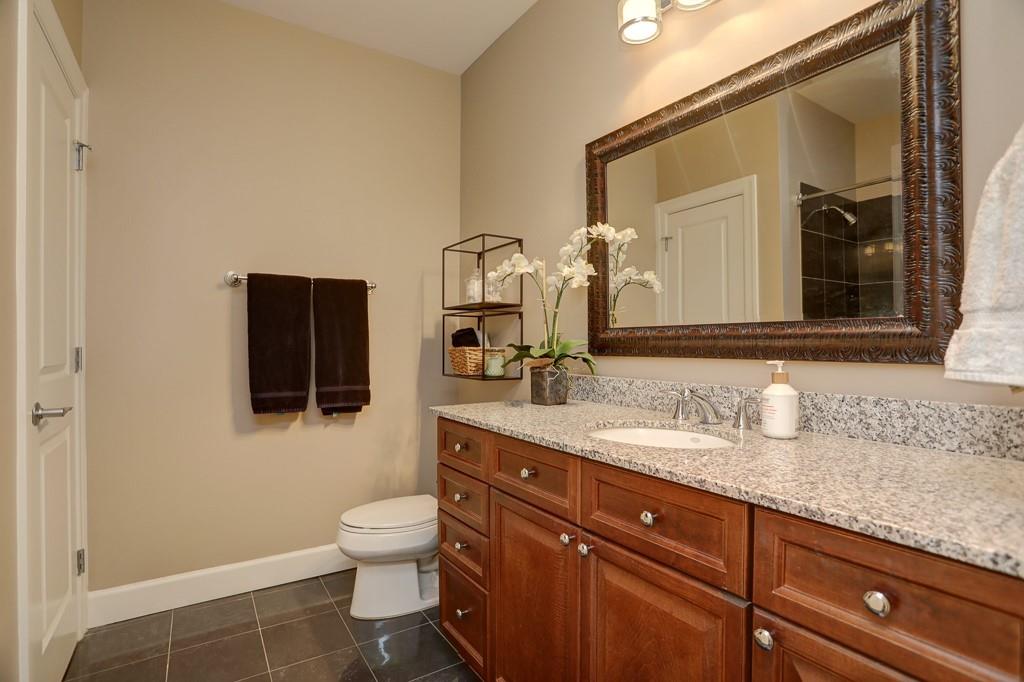 325 East Paces Ferry Road Northeast, Unit 1510 Atlanta, GA 30305 - Photo 19 of 33 a bathroom with a granite countertop toilet sink and mirror