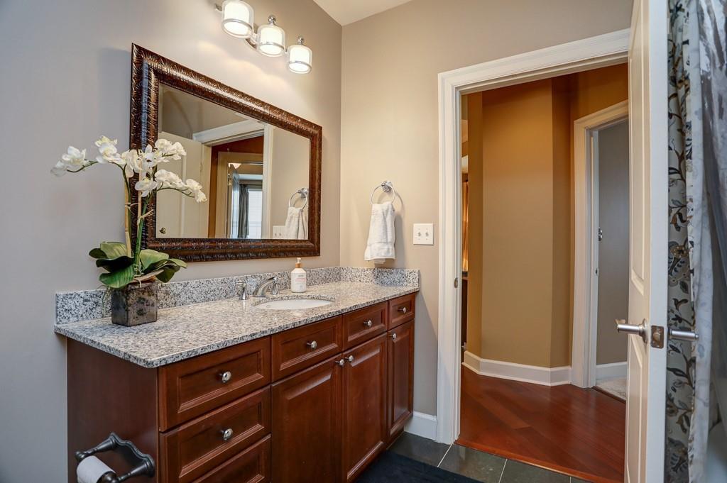 325 East Paces Ferry Road Northeast, Unit 1510 Atlanta, GA 30305 - Photo 20 of 33 a bathroom with a granite countertop sink and a mirror
