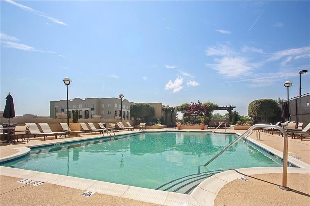 325 East Paces Ferry Road Northeast, Unit 1510 Atlanta, GA 30305 - Photo 26 of 33 a view of a swimming pool with a lawn chairs
