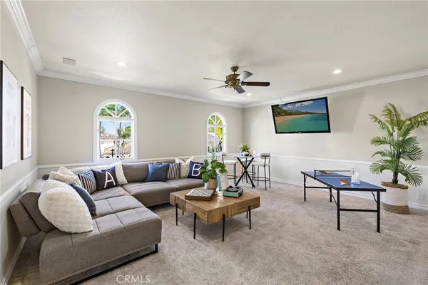 a living room with furniture a chandelier and a flat screen tv