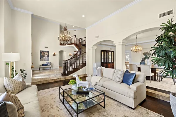 a living room with furniture stairs and a potted plant