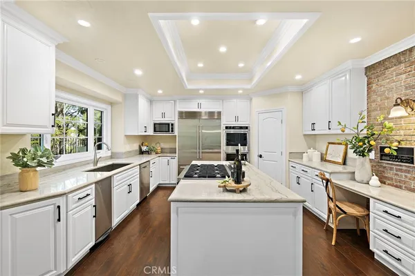 a kitchen with a sink a stove cabinets and wooden floor