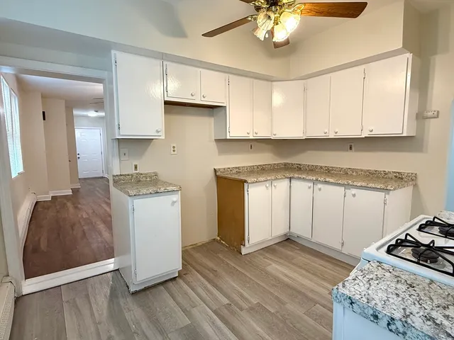 a kitchen with a stove cabinets and wooden floor