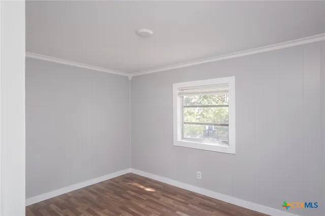 an empty room with a window and wooden floor