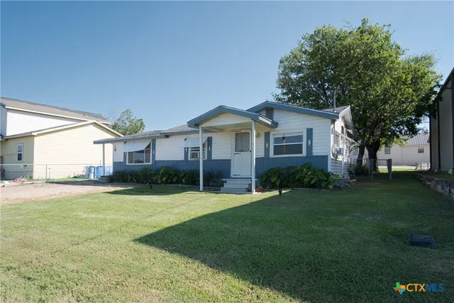 a front view of a house with a yard and trees