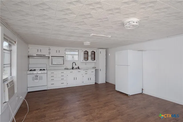 a kitchen with cabinets and wooden floor