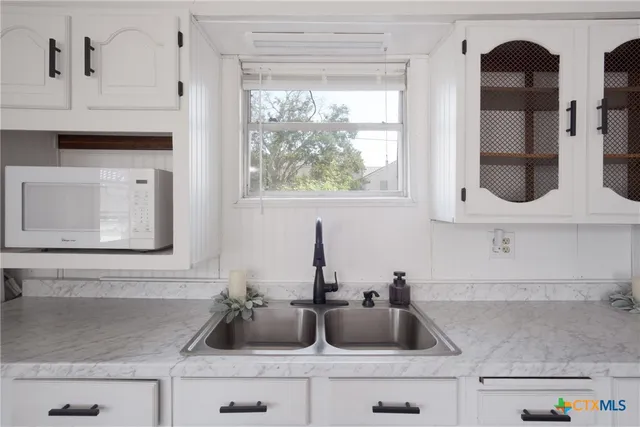 a kitchen with white cabinets and a sink