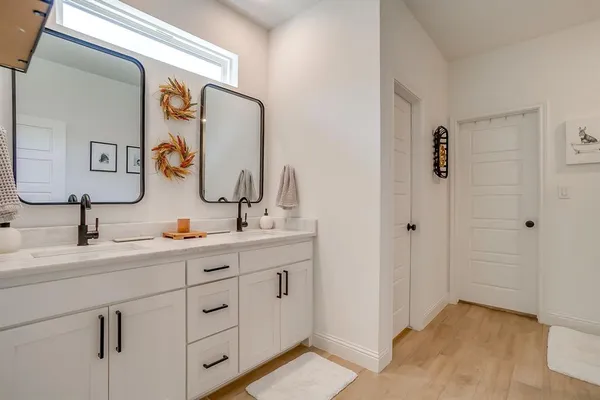 a bathroom with double sink and a mirror