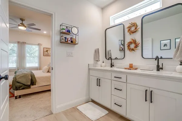 a en suite bathroom with a double vanity sink and a mirror