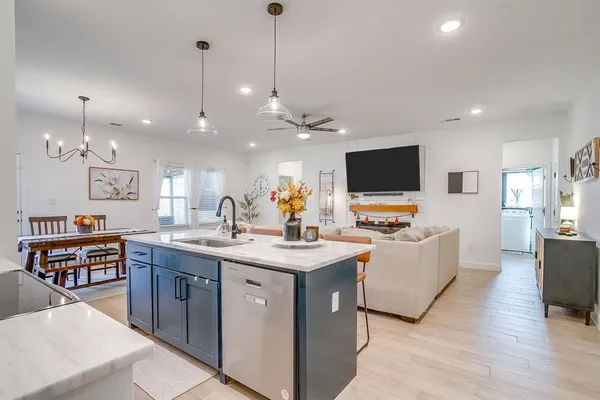 a view of living room kitchen with stainless steel appliances granite countertop and a view of living room