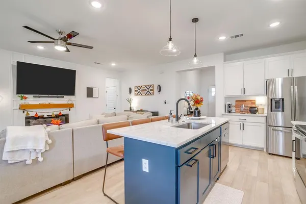 a kitchen that has a lot of cabinets a sink and a refrigerator