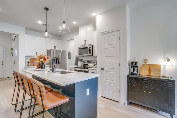 a kitchen with kitchen island granite countertop a sink stove and refrigerator
