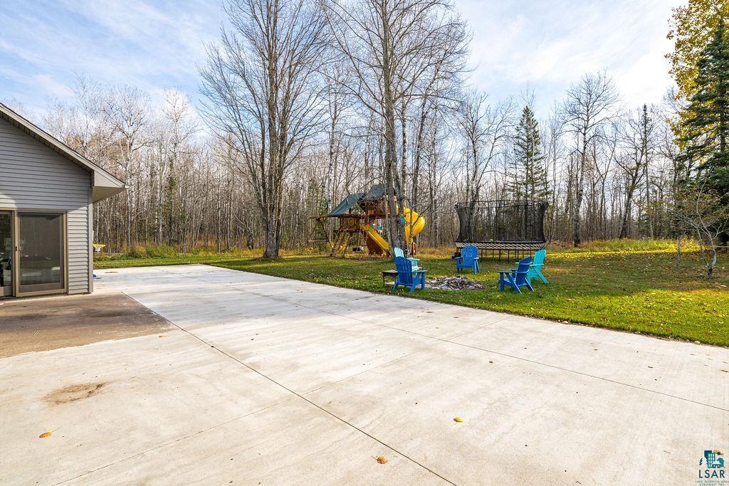 6048 Lakewood Road Duluth, MN 55804 - Photo 13 of 65 View of patio featuring a playground, a forest view, and a trampoline