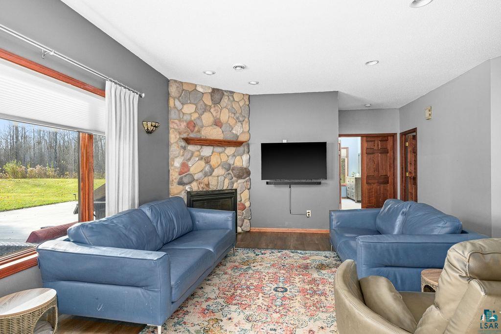 6048 Lakewood Road Duluth, MN 55804 - Photo 27 of 65 Living area with a stone fireplace, healthy amount of natural light, and wood finished floors