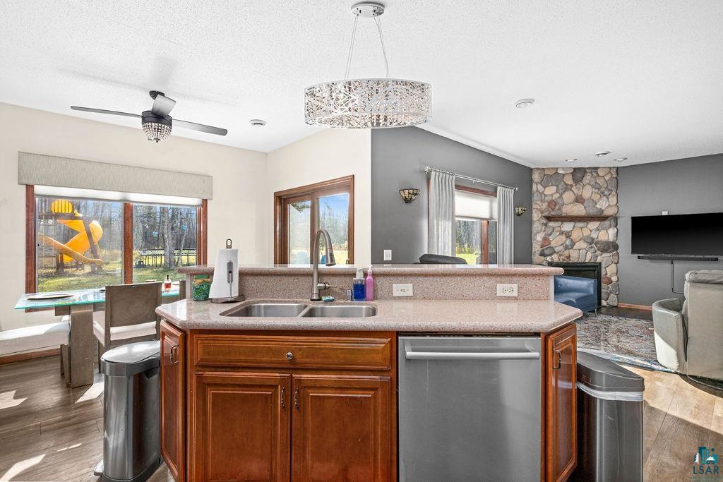 6048 Lakewood Road Duluth, MN 55804 - Photo 64 of 65 Kitchen featuring dark wood finished floors, stainless steel dishwasher, a kitchen island with sink, decorative light fixtures, and open floor plan