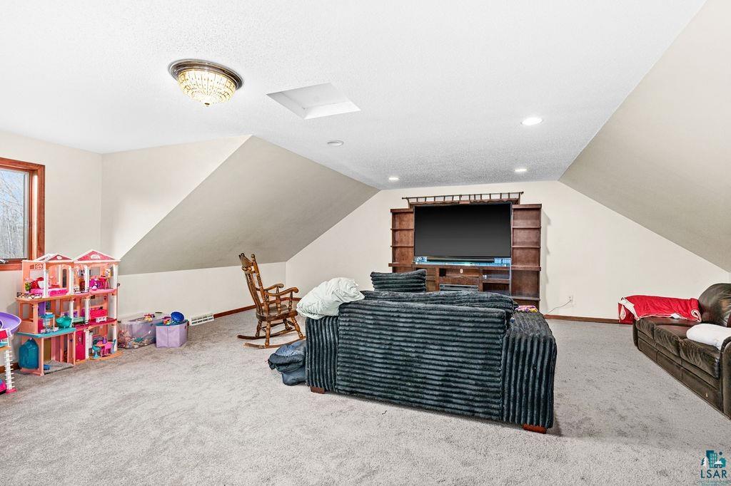 6048 Lakewood Road Duluth, MN 55804 - Photo 40 of 65 Playroom featuring carpet, lofted ceiling, and a textured ceiling