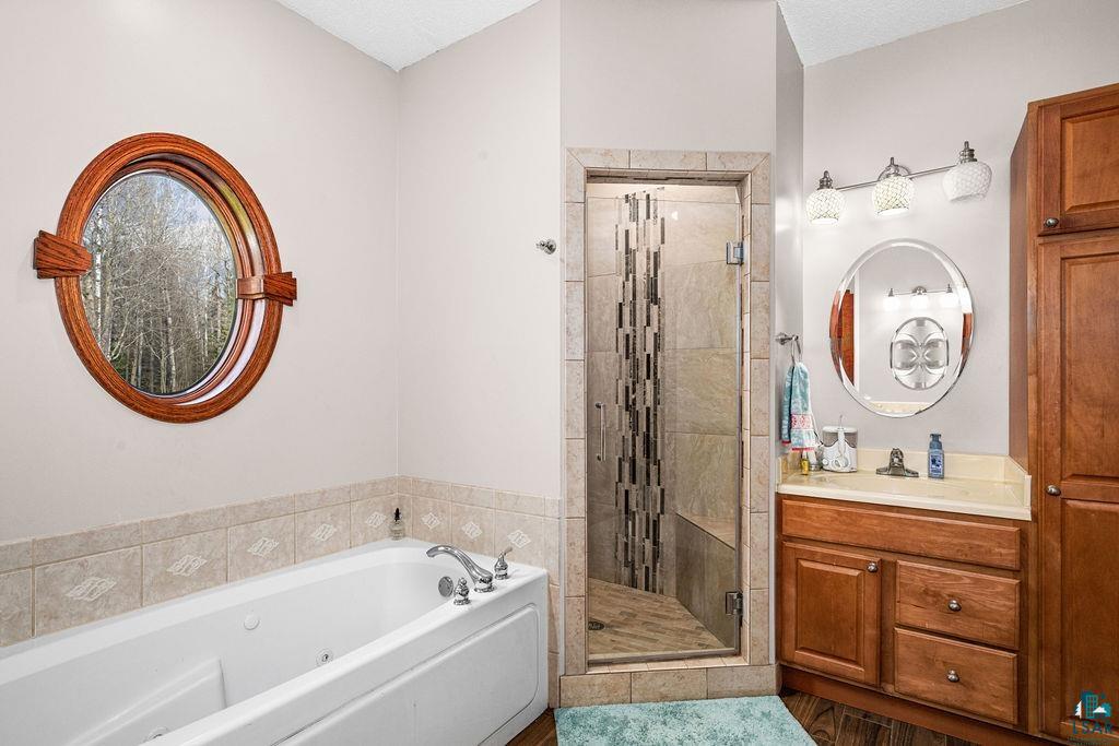 6048 Lakewood Road Duluth, MN 55804 - Photo 55 of 65 Bathroom with vanity, a tub with jets, and a shower stall