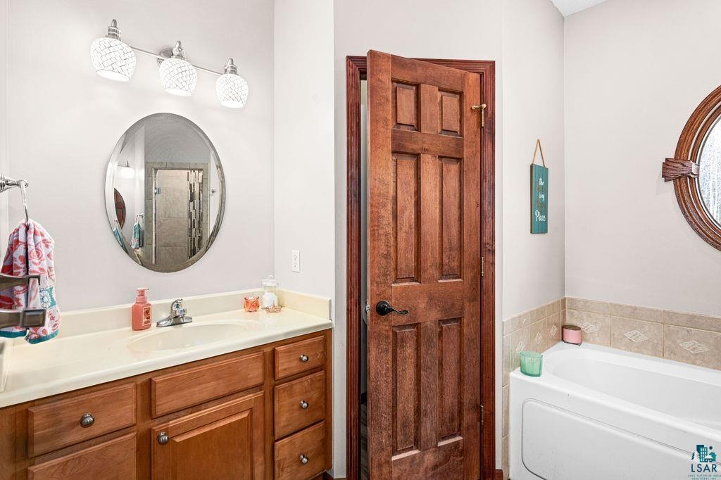 6048 Lakewood Road Duluth, MN 55804 - Photo 56 of 65 Bathroom featuring vanity, a garden tub, and a stall shower