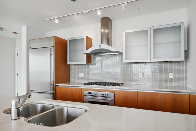 a kitchen with stainless steel appliances kitchen island a refrigerator sink and stove