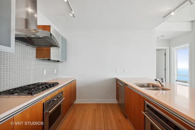 a kitchen with sink stove and cabinets