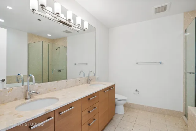a bathroom with a granite countertop sink a toilet and mirror