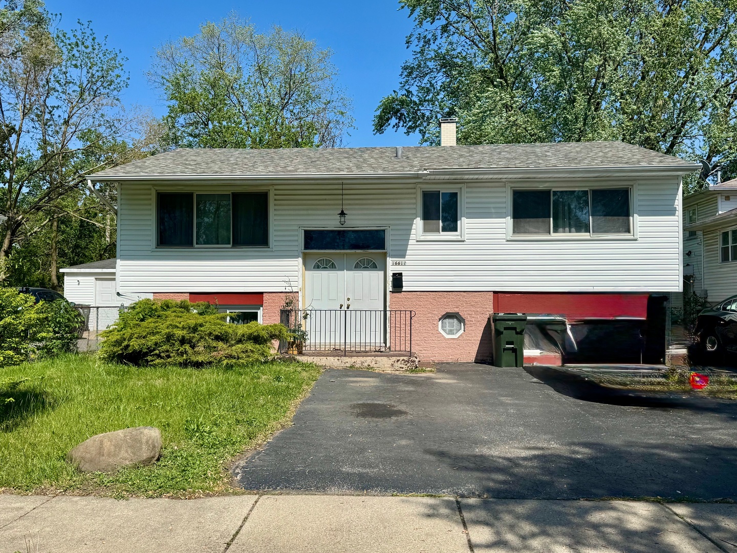 a view of a white house with a small yard and a large tree