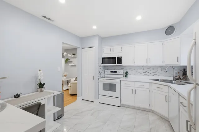 a kitchen with granite countertop a sink stove and cabinets