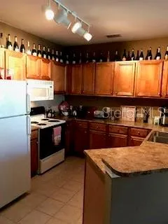 a kitchen with granite countertop a sink a stove and refrigerator