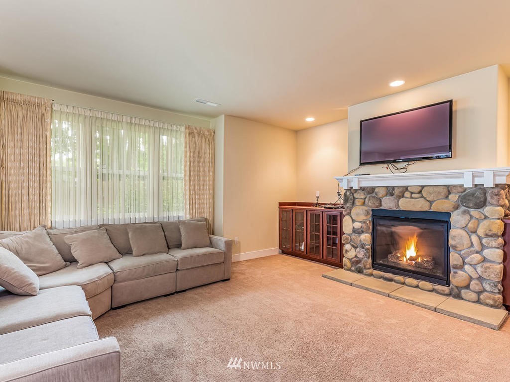 5111 Northeast 25th Street Renton, WA 98059 - Photo 16 of 29 a living room with furniture a flat screen tv and a fireplace