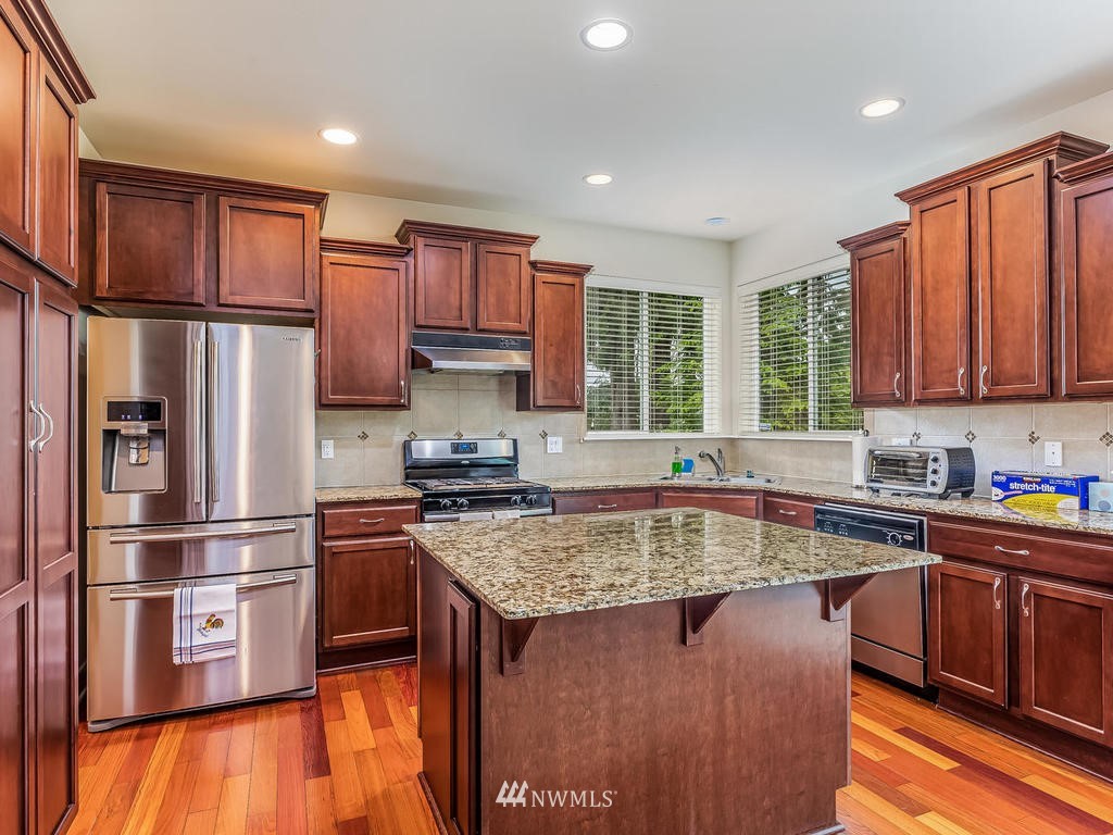 5111 Northeast 25th Street Renton, WA 98059 - Photo 9 of 29 a kitchen with stainless steel appliances granite countertop a refrigerator sink and cabinets