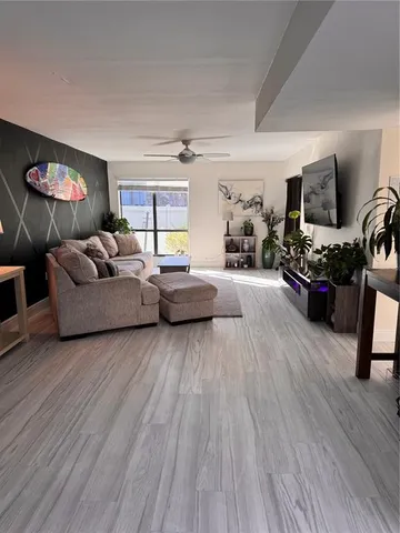 a living room with furniture and a wooden floor