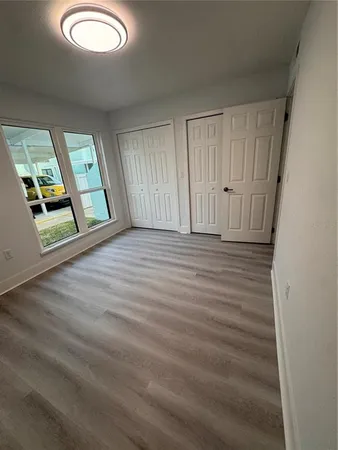 an empty room with mirror and windows