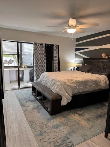 a bedroom with a bed and large mirror with window