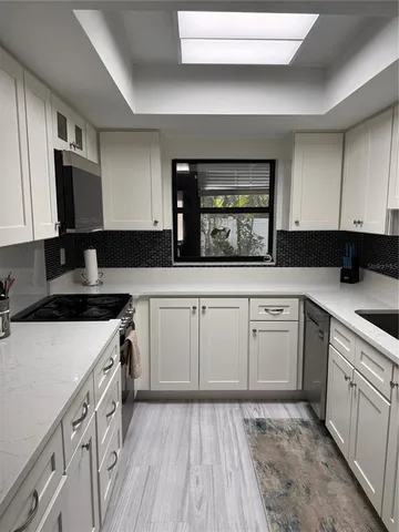 a kitchen with granite countertop a sink stove and cabinets