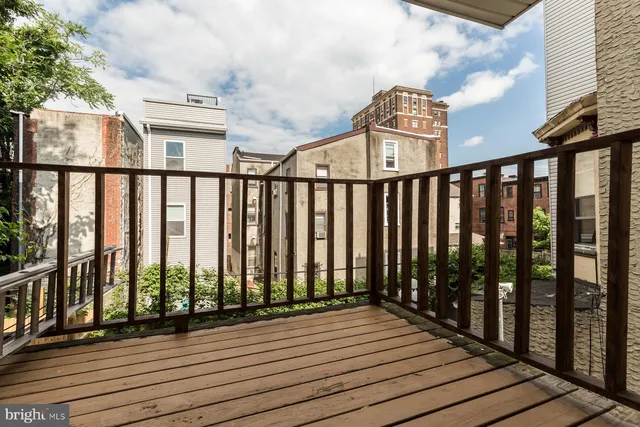 a view of a balcony with wooden floor and fence