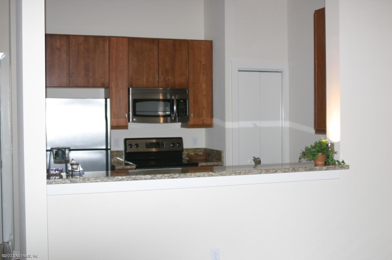 1661 Riverside Avenue, Unit 410 Jacksonville, FL 32204 - Photo 10 of 19 a kitchen with granite countertop a refrigerator and a stove top oven