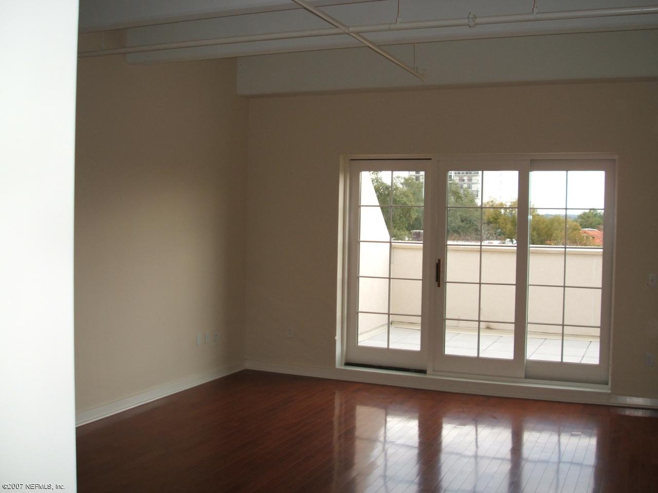 1661 Riverside Avenue, Unit 410 Jacksonville, FL 32204 - Photo 3 of 19 an empty room with wooden floor and windows