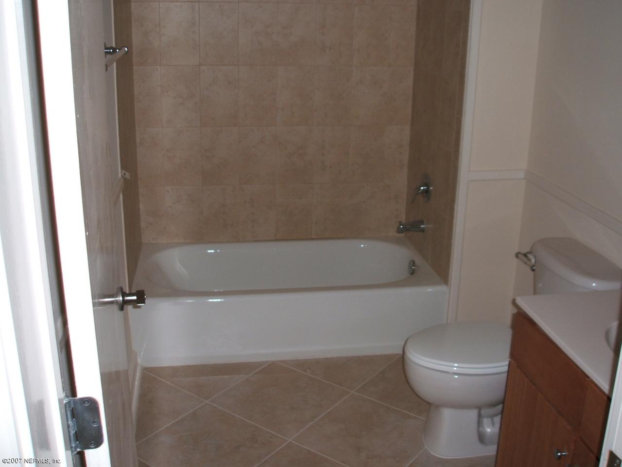 1661 Riverside Avenue, Unit 410 Jacksonville, FL 32204 - Photo 6 of 19 a white bath tub sitting next to a toilet