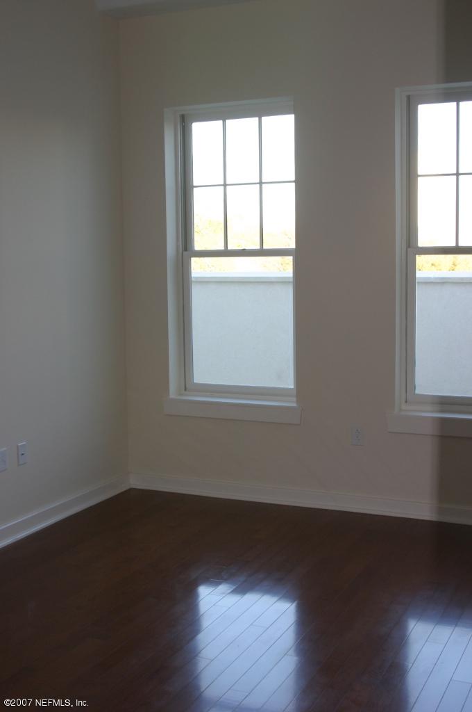 1661 Riverside Avenue, Unit 410 Jacksonville, FL 32204 - Photo 8 of 19 an empty room with wooden floor and windows