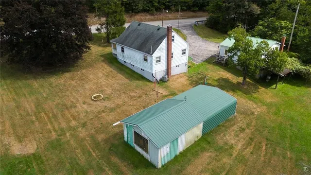 an aerial view of a house with a yard basket ball court and outdoor seating