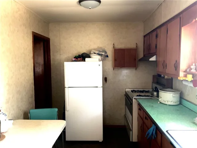 a kitchen with stainless steel appliances granite countertop a refrigerator a sink dishwasher a stove with wooden floor