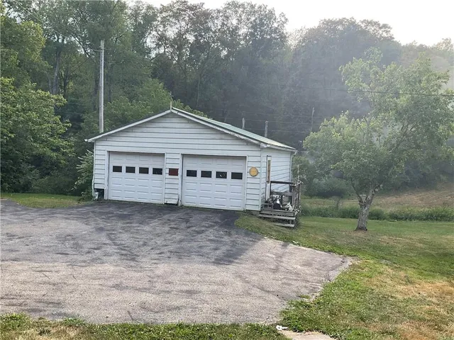 a view of a house with a yard and large tree