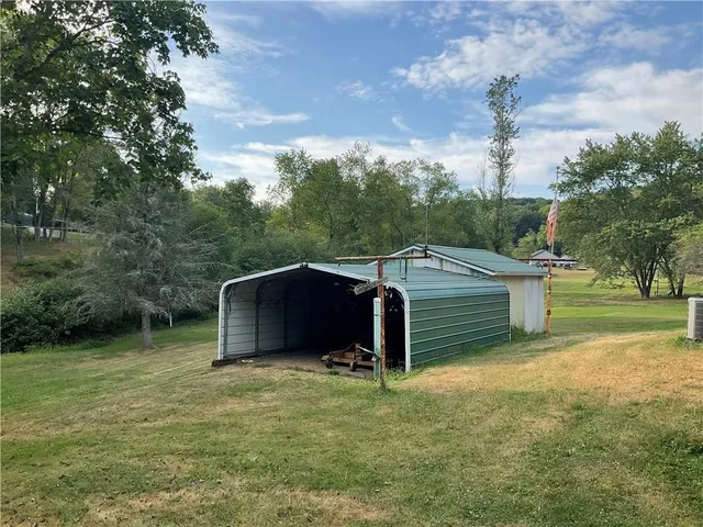 a view of a house with backyard and trees