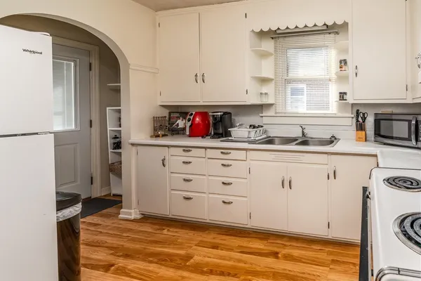 a kitchen with a refrigerator sink and cabinets