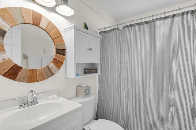a bathroom with a sink mirror vanity and toilet